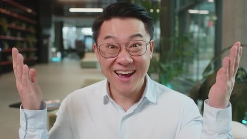 Chinese Young Businessman in Shirt Looking at Camera Shocked By Sudden Victory in Office Lobby