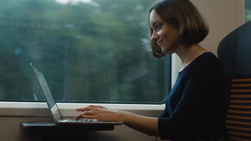 Woman Works on Laptop While Traveling on Train