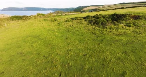 Flying Over Green Fields To Reveal Dramatic Coast Line Aerial View