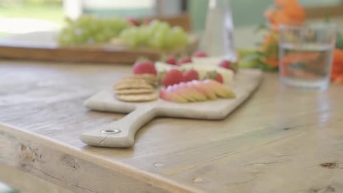 slide close up of vegetarian appetiser with cheese and fruit grapefruit strawberry on wooden table c