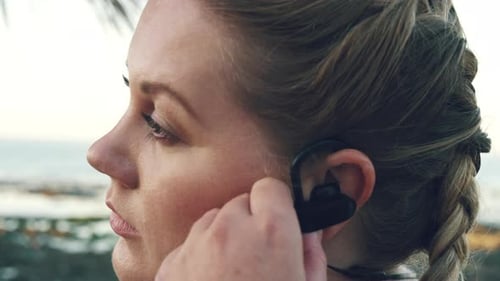 Woman streaming audio podcast, calm beach and breathe relax in outdoor fitness workout