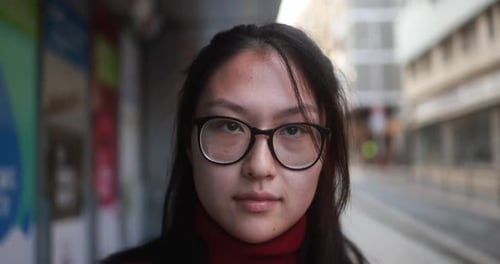 Young Woman with Glasses Stares Intently at Camera