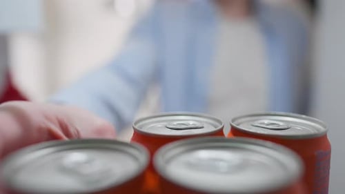 Réfrigérateur, jeune propriétaire prend joyeusement une canette de boisson en métal sur l'étagère du réfrigérateur