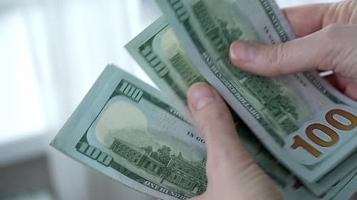 Counting stack of one hundred dollar bills