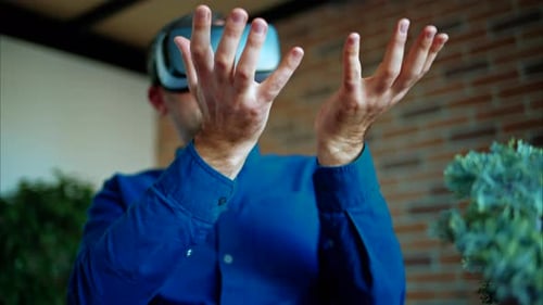 Man gesturing while using a Virtual Reality headset in an office