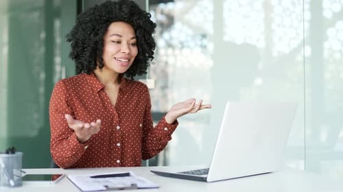 Confident african american female manager talking on a video call using a laptop sitting
