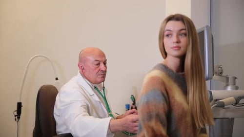 A Doctor Listens to a Young Patient with a Stethoscope in the Clinic Concept of Diagnosis and