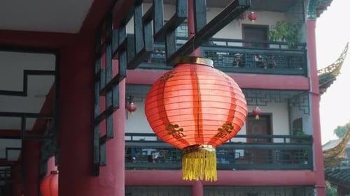 Traditional Red Chinese Lantern Hanging Outside a Building with Asian Architectural Elements in the