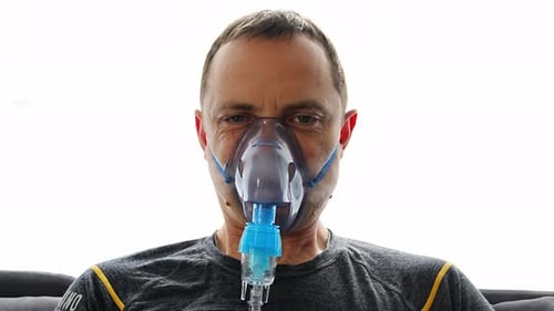 Unhealthy Man Wearing Nebulizer Mask Breathing in Home Health Medical Equipment and People Concept