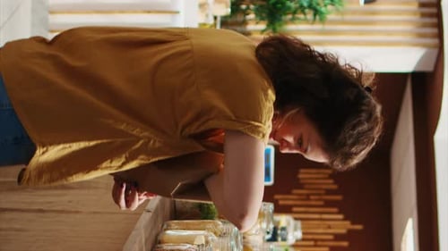 Vídeo vertical: Mujer en un taller sin residuos usando una bolsa de papel