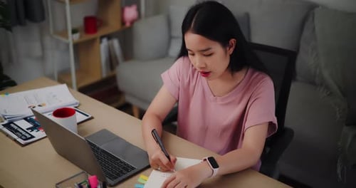 Woman Working on Laptop at Desk in Home Office