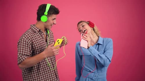 Joyful Couple Dancing and Listening to Music with Headphones While Enjoying a Fun Moment Together