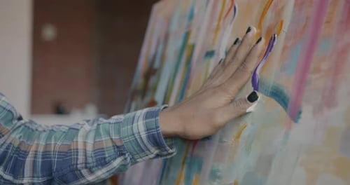 Hand Applying Paint to Abstract Art Canvas