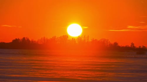 Time lapse on close up view of the sun setting down in the orange view with clouds moving background