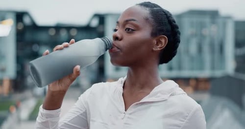 City. fitness and black woman drinking water, tired and health with hydration, workout and training