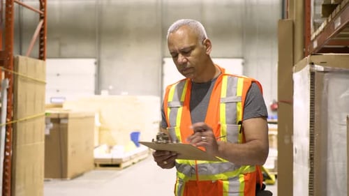 Portrait Confident Male Warehouse Supervisor with Board