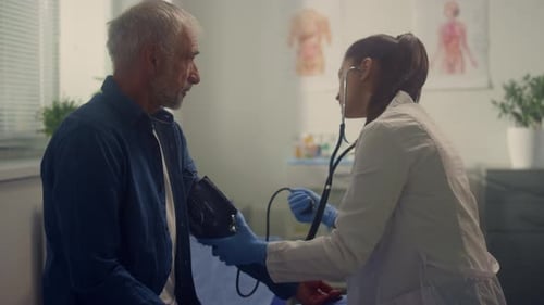Woman Cardiologist Measuring Blood Pressure Senior Patient in Hospital Office Closeup. Young