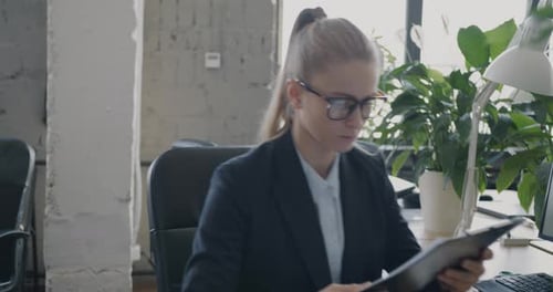Business Woman Reviews Reports With Colleague in Office