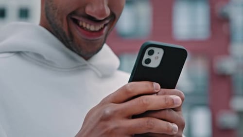 Man Smiling Looking At Phone in City