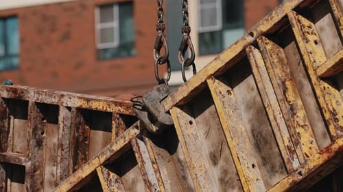 Crane Lifting Steel Formwork Panels at Construction Site