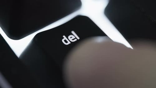 Pressing and holding delete button on black computer keyboard