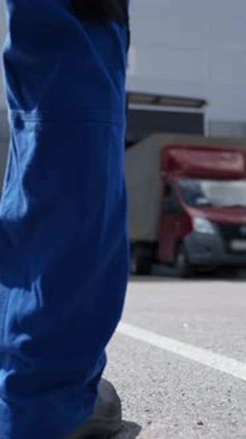 Vertical of Engineer Walks to Truck Waiting for Unloading at Terminal