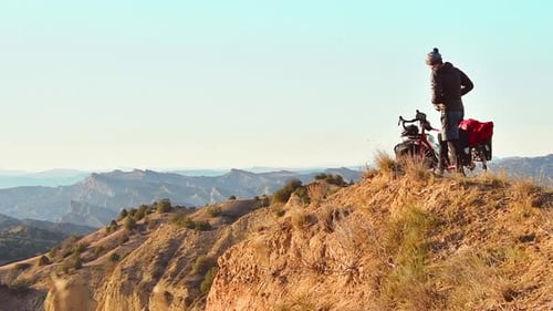 Cyclist Exploring Remote Mountainous Landscape During the Day