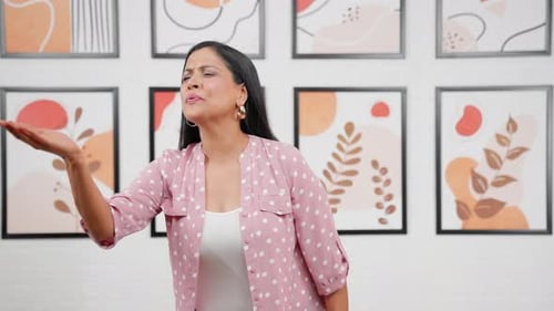 Happy Woman Waving and Blowing Kisses Indoors