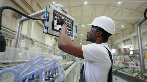 African Engineer Working at Programmable CNC Machine in Factory Industries