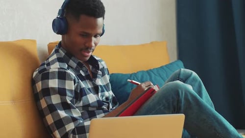 Young Adult Studying at Home with Laptop