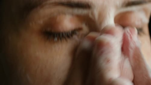 Mujer lavándose la cara con espuma limpiadora de cerca