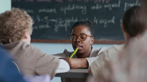 Teacher Helping Student in Classroom