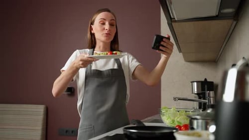 Une jeune blogueuse vidéo diffuse en direct des vidéos en ligne enseignant la cuisine à la maison