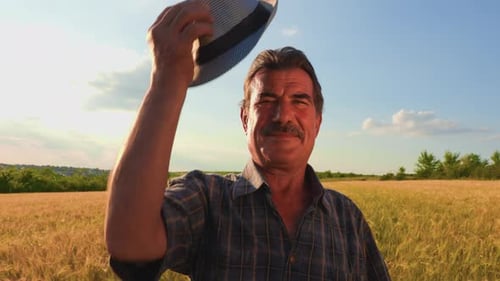 Friendly Farmer Smiling in Golden Wheat Field