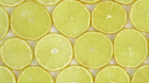 Jugosos cítricos giratorios. Primer plano de rodajas de limón, comida de verano, fondo