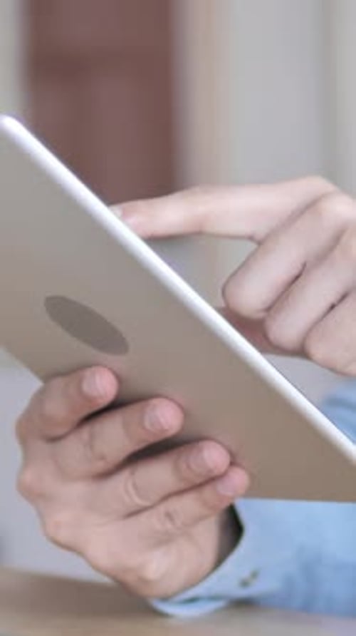 Man's Hands Using a Tablet Device indoors
