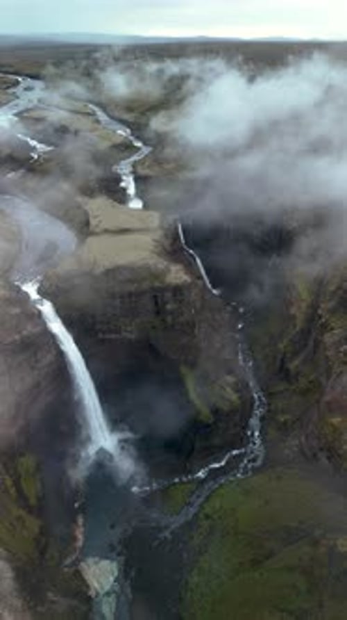 Breathtaking Aerial View of Waterfall in Rugged Landscape