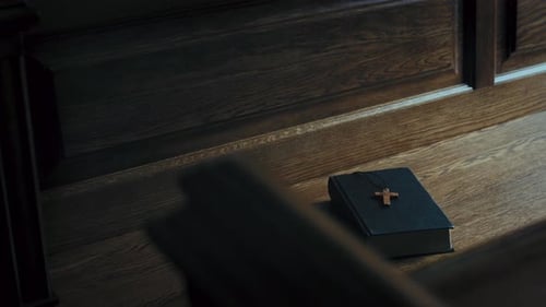 Christian Cross on Holy Bible on Wooden Table in Church