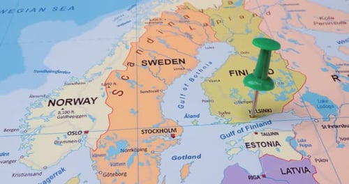 Finland - Travel concept with green pushpin on the world map. The location point on the map points