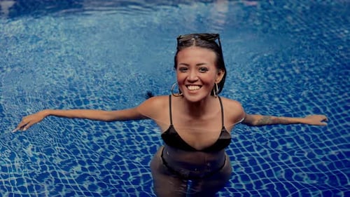 Smiling Woman Relaxing in Tropical Swimming Pool
