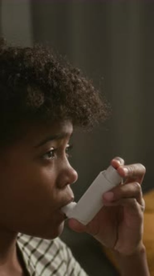 Close-Up of Boy Using Medical Inhaler for Asthma Management