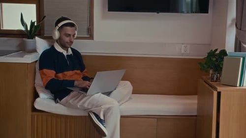 Male Student or Freelancer Working on Laptop in Cozy Studio Flat