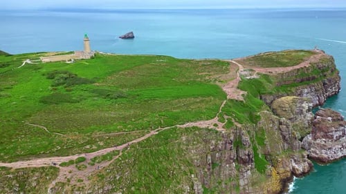 Drohne fliegt in Richtung Leuchtturm Cap Fréhel an der bretonischen Küste - Frankreich
