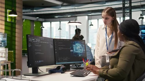 Women Discussing Code in Modern Open Office