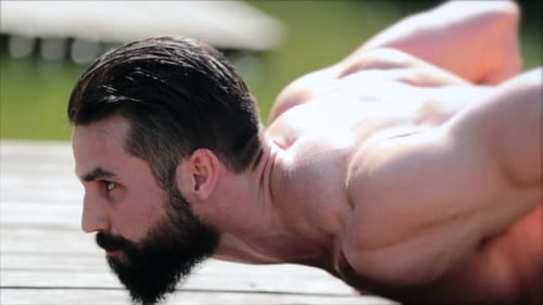 Muscular Man Does Yoga Downward Dog on Dock