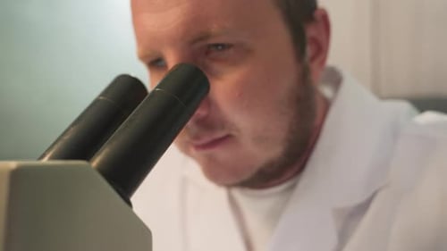 Scientist Using Microscope in a Brightly Lit Lab