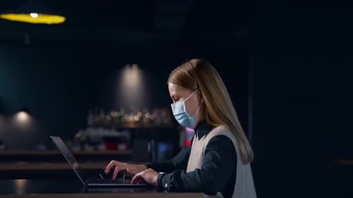 Femme d'affaires masquée travaillant dans un lieu de travail moderne. Mettez en quarantaine le travail commercial.