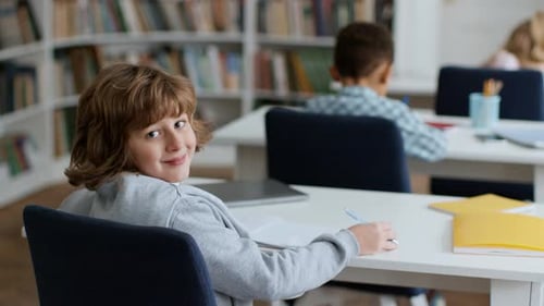Smiling Child at Desk in Classroom