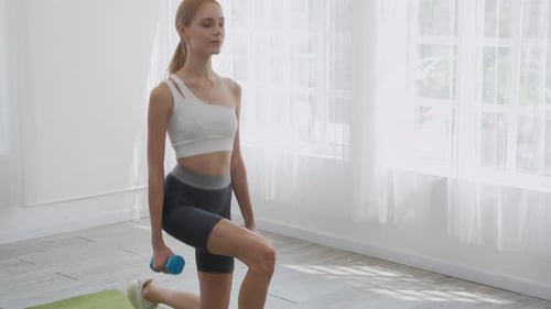 Young woman workout with holding dumbbell and doing stretching squat for muscle leg and hands.