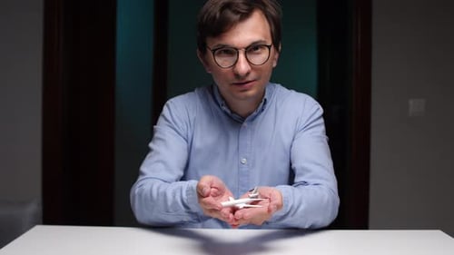 Man Holding Toy Airplane Indoors